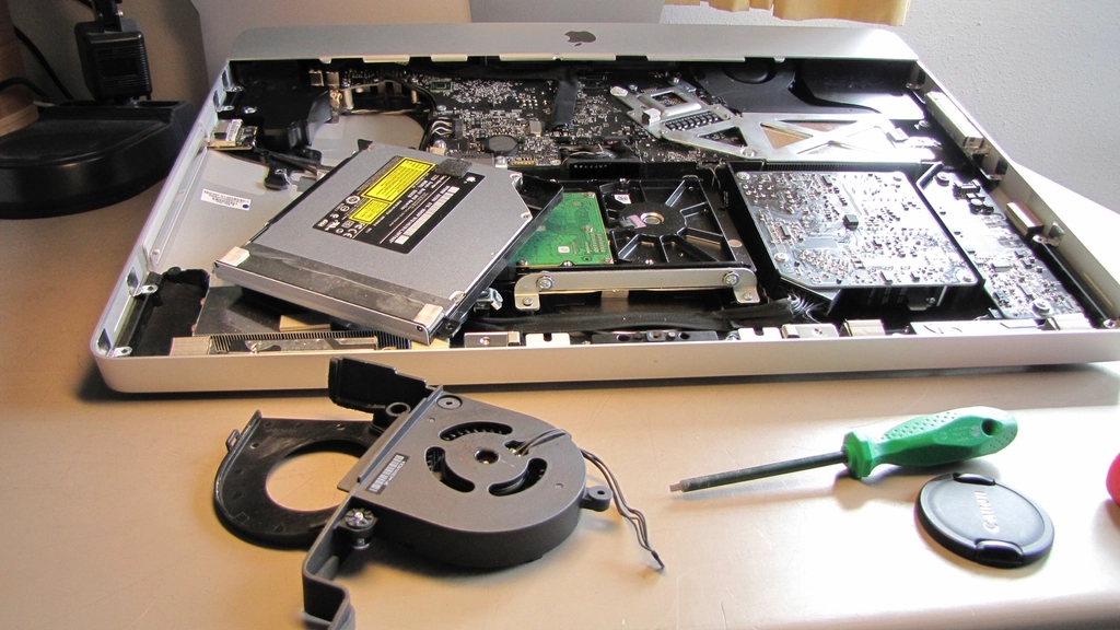 A computer opened up on the workbench mid-repair