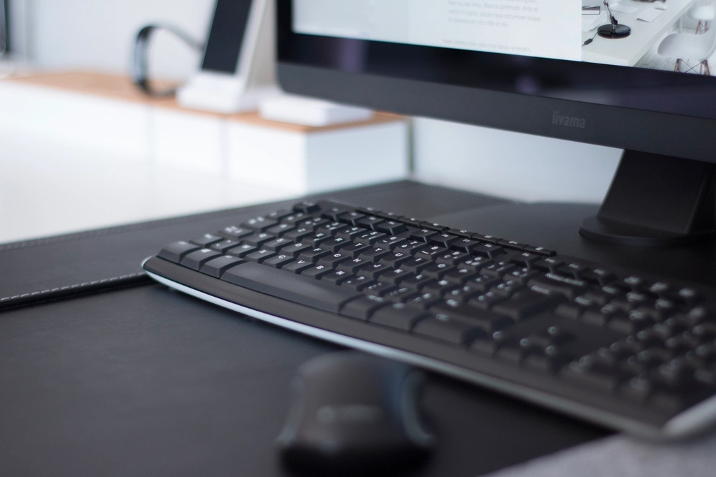 A tidy desk with a monitor and keyboard, ready to work