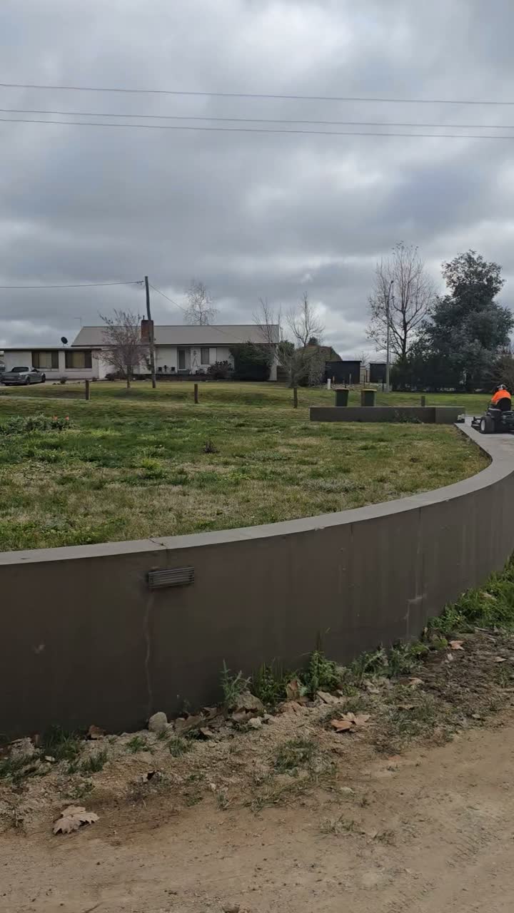 Freshly mown lawn above a rendered retaining wall