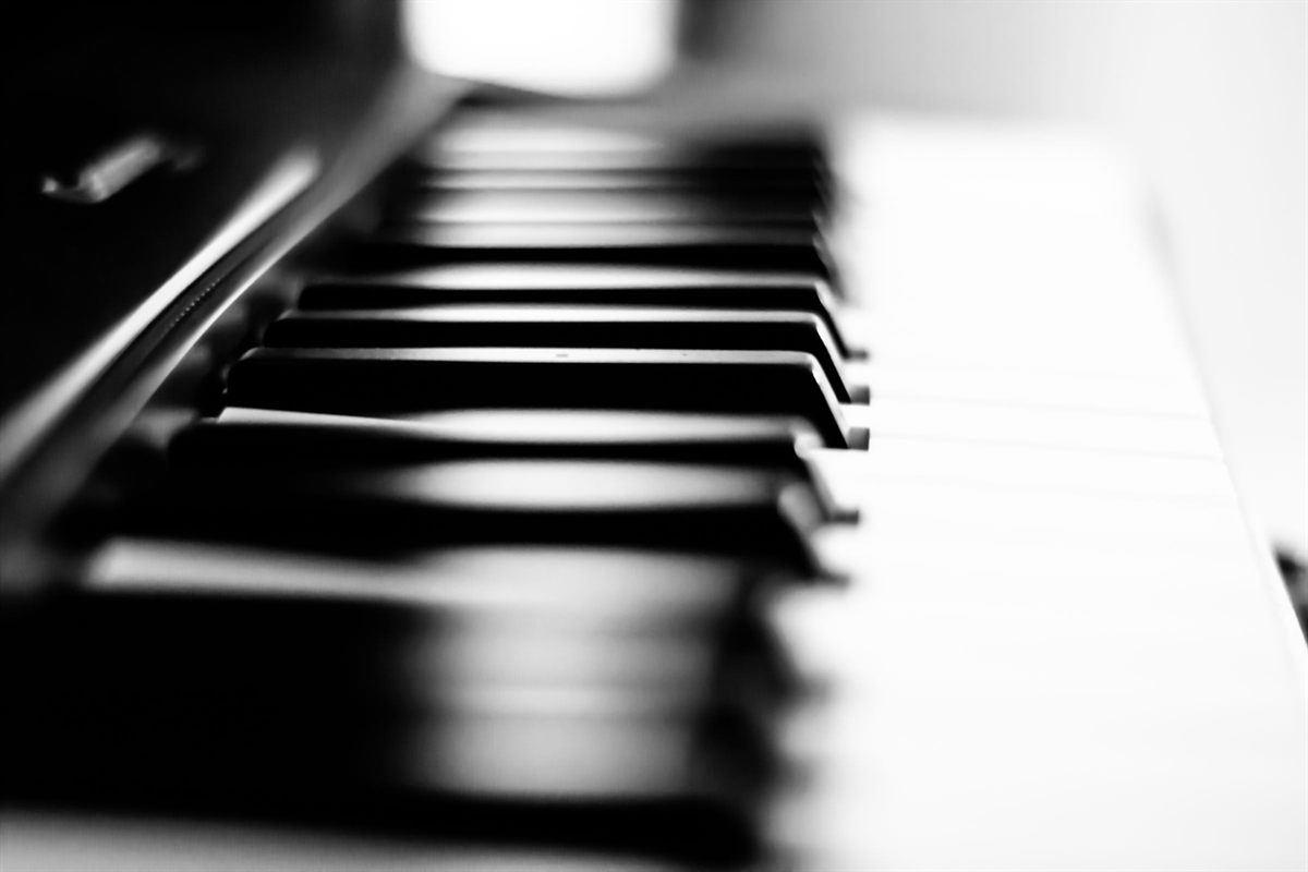 Piano keys dissolving into soft focus, in monochrome